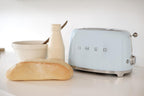 Smeg, 2x2 TSF01PBEU -Toaster, 2 Schlitze für 2 Scheiben, 6 Vergoldungsniveaus, Heizfunktion, Abtau- und Bagel- Funktion, Sammelschublade, 950W, Pastellblau